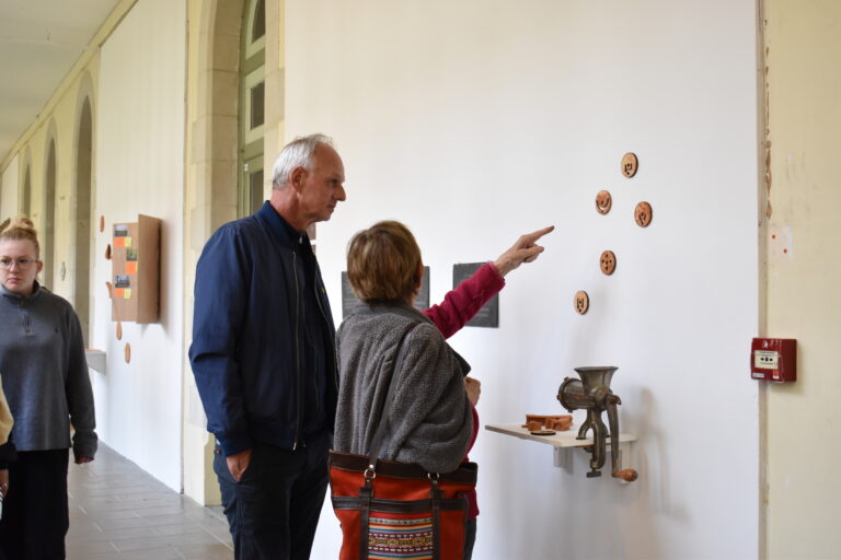 deux personnes regardent de près des éléments d'exposition